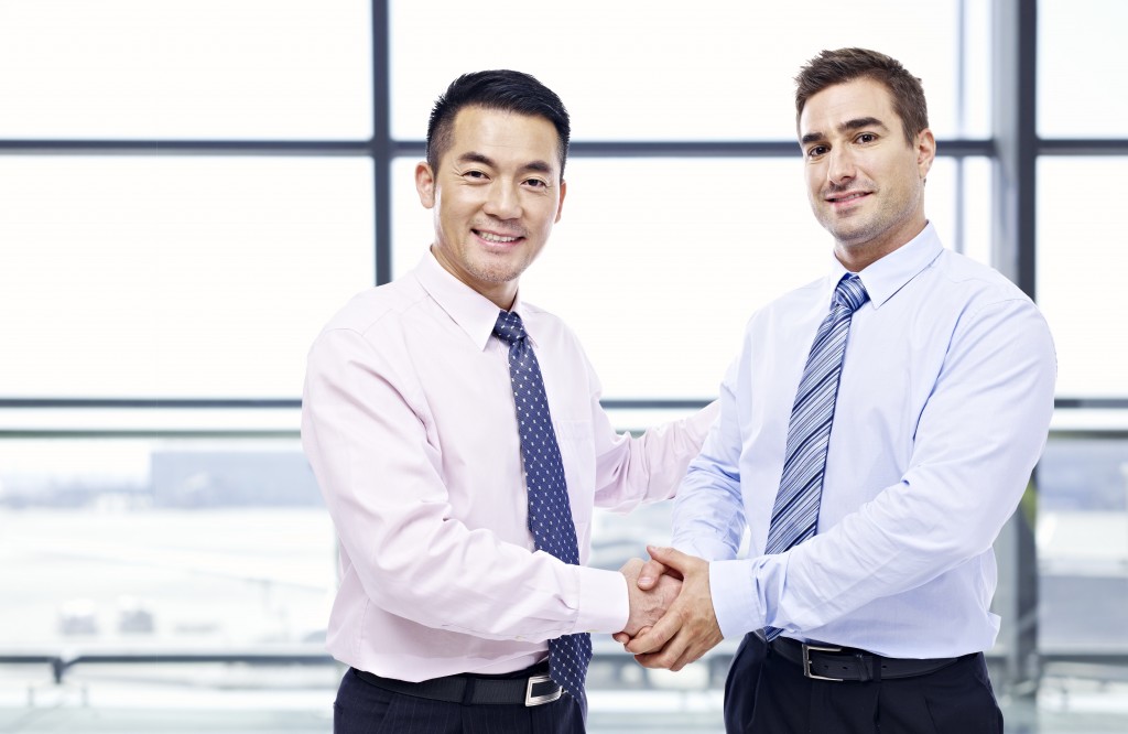 Asian expat shaking colleague's hand